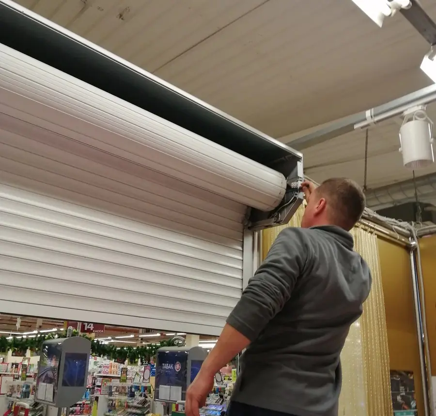 Technicien intervenant sur une porte de garage enroulable